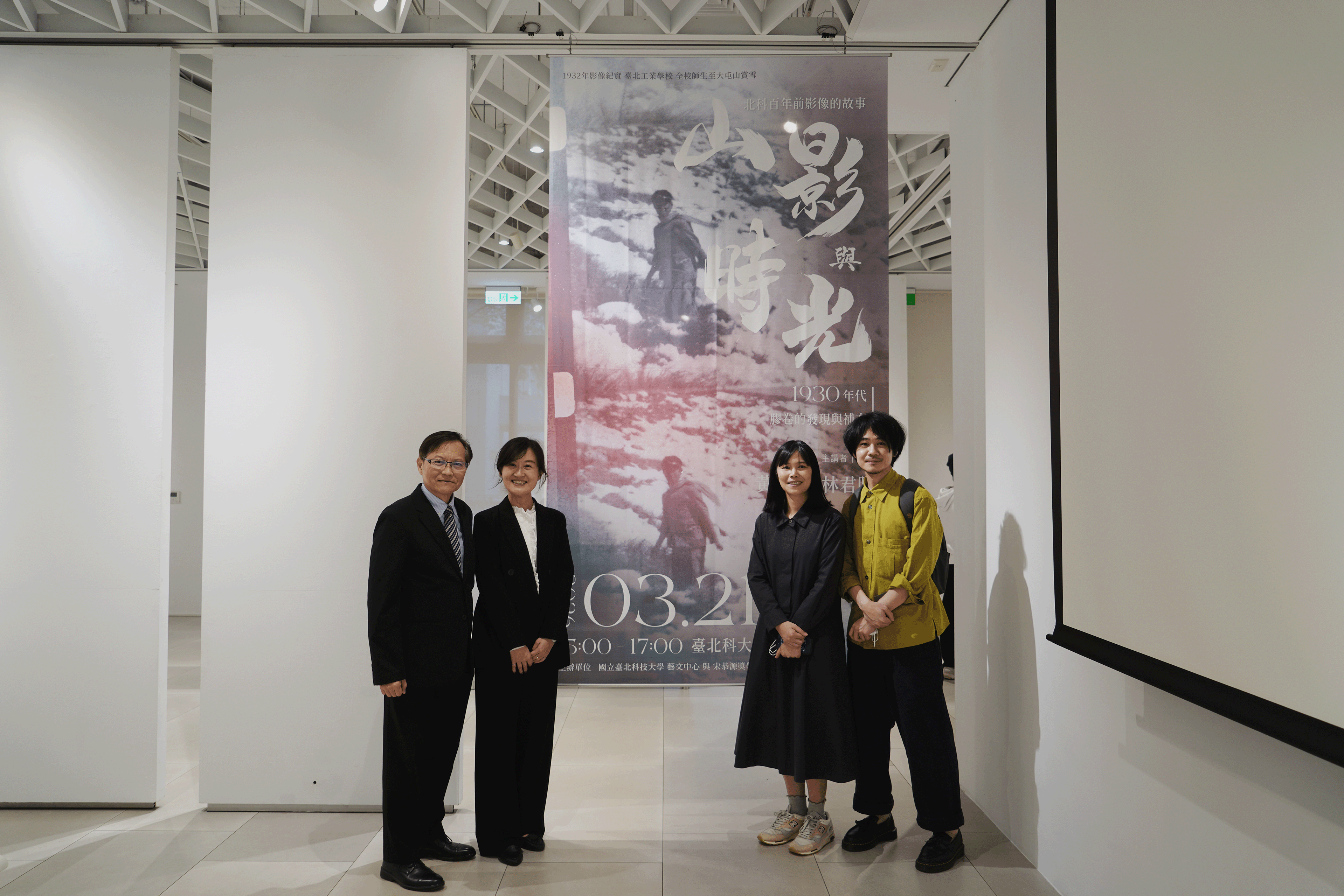 四位與會貴賓在「山影與時光」大型海報前合影。